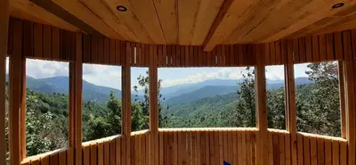 a room with a large window with a view of mountains at LES CABANES DE LUTINA in Poggio-Marinaccio