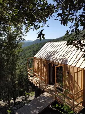 a wooden cabin with a view of the mountains at LES CABANES DE LUTINA in Poggio-Marinaccio