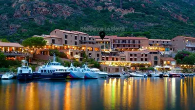 a group of boats docked in a marina at night at Appartements Les résidences du port La Siesta in Porto Ota
