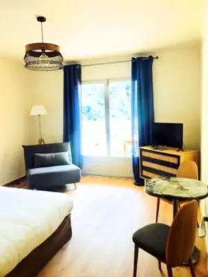 a bedroom with a bed and a chair and a window at Appartements Les résidences du port La Siesta in Porto Ota