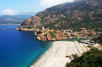 a view of a beach with a town on a mountain at Appartements Les résidences du port La Siesta in Porto Ota