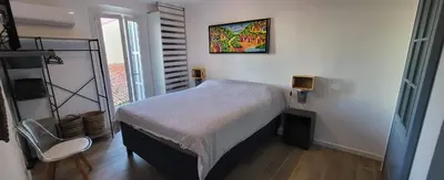 a small bedroom with a bed and a picture on the wall at Superbe T2 avec balcons, Vieux Port, Hyper centre Ajaccio in Ajaccio