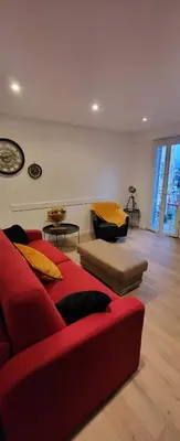 a living room with a red couch and yellow pillows at Superbe T2 avec balcons, Vieux Port, Hyper centre Ajaccio in Ajaccio