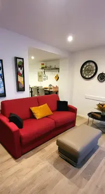 a red couch in a living room with a table at Superbe T2 avec balcons, Vieux Port, Hyper centre Ajaccio in Ajaccio