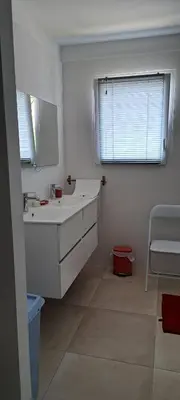 a white bathroom with a sink and a window at JOLIE VILLA dans un endroit paisible, à 3 mn de la Mer et de la Montagne in Ventiseri