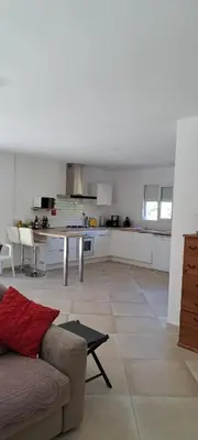 a living room with a couch and a kitchen at JOLIE VILLA dans un endroit paisible, à 3 mn de la Mer et de la Montagne in Ventiseri