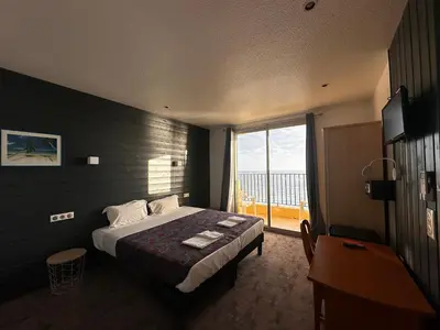 a hotel room with a bed and a large window at Hôtel A RENA D'ORU in Coggia