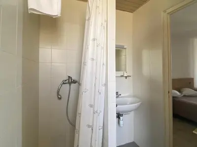 a bathroom with a shower and a sink at Hôtel A RENA D'ORU in Coggia