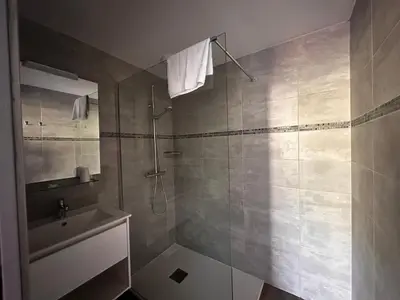 a bathroom with a shower and a sink at Hôtel A RENA D'ORU in Coggia