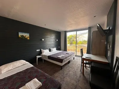 a hotel room with two beds and a window at Hôtel A RENA D'ORU in Coggia