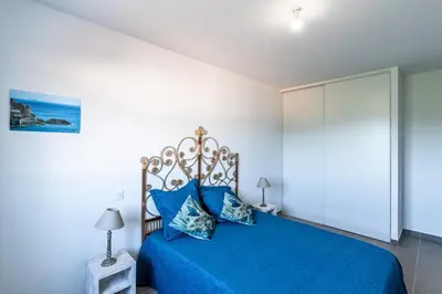 a bedroom with a blue bed with blue pillows at Les Terres Rouges in Aléria
