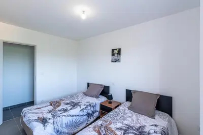 a room with two beds and a table in it at Les Terres Rouges in Aléria