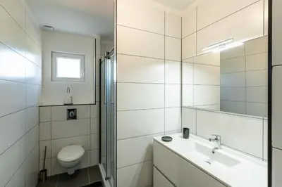 a white bathroom with a sink and a toilet at Les Terres Rouges in Aléria