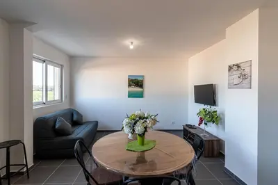 a living room with a table and a couch at Les Terres Rouges in Aléria