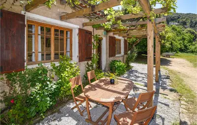 a wooden table and chairs in front of a house at Lovely Home In Coti Chiavari With Wifi in Coti-Chiavari