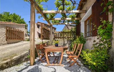 a wooden table and chairs under a pergola at Lovely Home In Coti Chiavari With Wifi in Coti-Chiavari