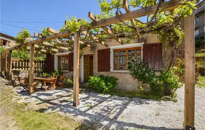 a house with a wooden pergola and a table at Lovely Home In Coti Chiavari With Wifi in Coti-Chiavari