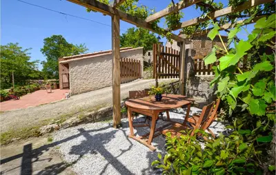 a wooden table and chairs under a pergola at Lovely Home In Coti Chiavari With Wifi in Coti-Chiavari