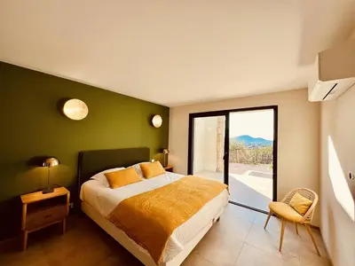 a bedroom with a bed and a large window at Casa di Bà - villa 2 chambres avec piscine à 10 minutes des plages in Afa