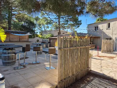 a wooden fence in a patio with a table and chairs at Fiori Di Cala Rossa Très beau studio au sein d'une résidence hôtelière avec piscine et plage Cala Rossa à 600m in Lecci