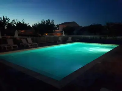 a swimming pool lit up at night at Villa climatisée A Nuciola Prunete Entre mer, montagne et piscine in Cervione