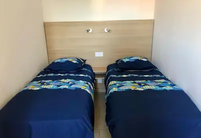 two beds in a small room next to each other at Appartement centre ville avec piscine et vue mer in Sari Solenzara