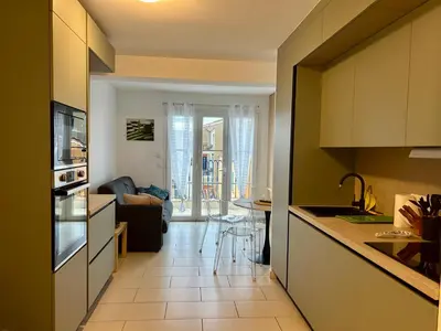 a kitchen and dining room with a table and chairs at Appartement centre ville avec piscine et vue mer in Sari Solenzara