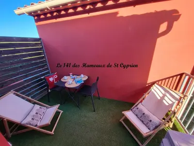 a table and chairs on a balcony with a sign on the wall at Joli T2 climatisé au calme à 10 mm de Porto-Vecchio dans une résidence de tourisme in Lecci