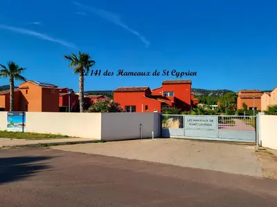 a fence in front of a building with palm trees at Joli T2 climatisé au calme à 10 mm de Porto-Vecchio dans une résidence de tourisme in Lecci