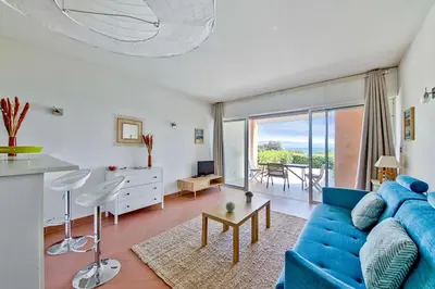 a living room with a blue couch and a table at Studio Rossi - Ajaccio - Welkeys in Ajaccio