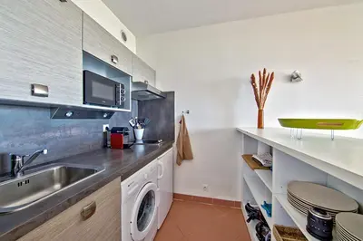 a kitchen with a sink and a washing machine at Studio Rossi - Ajaccio - Welkeys in Ajaccio