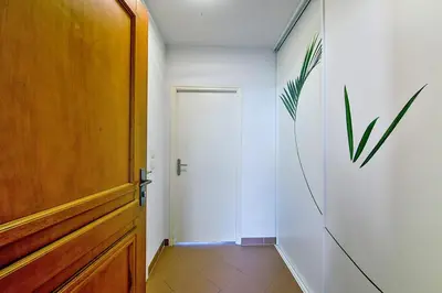 a hallway with a door and a plant on the wall at Studio Rossi - Ajaccio - Welkeys in Ajaccio