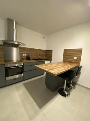 a kitchen with a wooden table and a chair at Gîte à la ferme chez Félix et Marie-Ca in Vallecalle