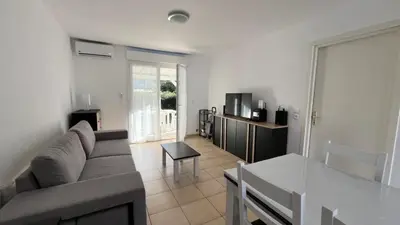 a living room with a couch and a table at Maison à Cervione Prunete jardin piscine accès direct plage in Cervione