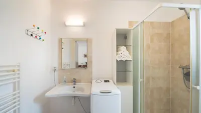 a bathroom with a toilet and a sink and a shower at Maison à Cervione Prunete jardin piscine accès direct plage in Cervione