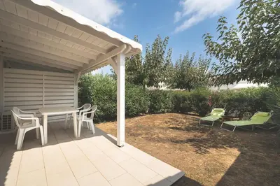 a patio with a table and chairs under a pavilion at Maison à Cervione Prunete jardin piscine accès direct plage in Cervione