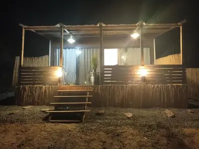 a wooden building with a porch at night at U San Francescu Maisonette Modulaire Type studio in Volpajola