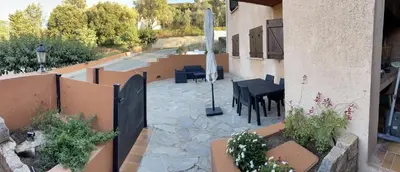 a patio with tables and chairs in a building at Chez Caro in Sartène