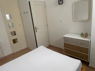 a bedroom with a bed and a dresser and a mirror at Chez Caro in Sartène