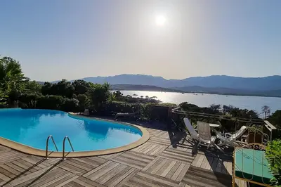a swimming pool on a deck with a view of the water at Villa charmante à Porto-Vecchio avec piscine in Porto-Vecchio