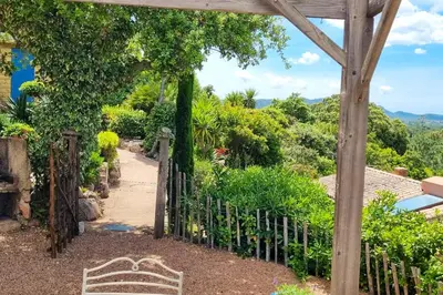 an entrance to a garden with a wooden gate at Villa charmante à Porto-Vecchio avec piscine in Porto-Vecchio