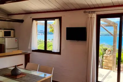 a dining room with a table and a view of the ocean at Villa charmante à Porto-Vecchio avec piscine in Porto-Vecchio