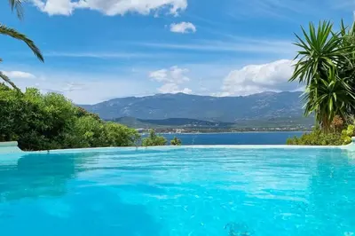 a swimming pool with a view of the water and mountains at Villa charmante à Porto-Vecchio avec piscine in Porto-Vecchio