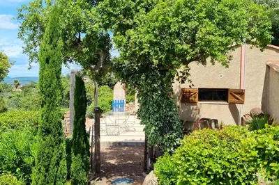 an entrance to a house with trees and bushes at Villa charmante à Porto-Vecchio avec piscine in Porto-Vecchio