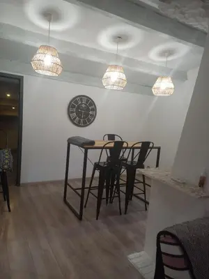 a dining room with a table and chairs and a clock at afa butrone sarrola in Afa