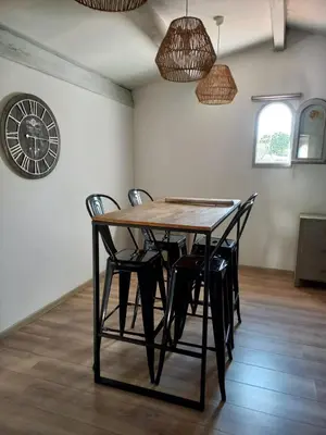 a dining room table with chairs and a clock on the wall at afa butrone sarrola in Afa