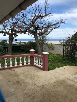 a pink fence with the beach in the background at Maison au calme avec terrain et vue sur la mer in Poggio-Mezzana