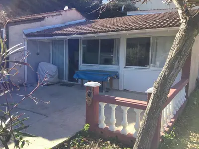 a porch of a house with a blue table on it at Maison au calme avec terrain et vue sur la mer in Poggio-Mezzana