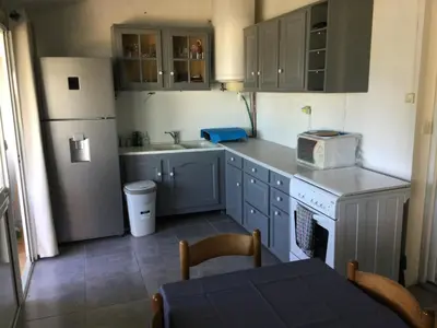 a small kitchen with a sink and a refrigerator at Maison au calme avec terrain et vue sur la mer in Poggio-Mezzana