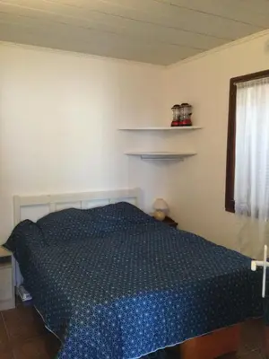 a bedroom with a blue bed in a room at Maison au calme avec terrain et vue sur la mer in Poggio-Mezzana